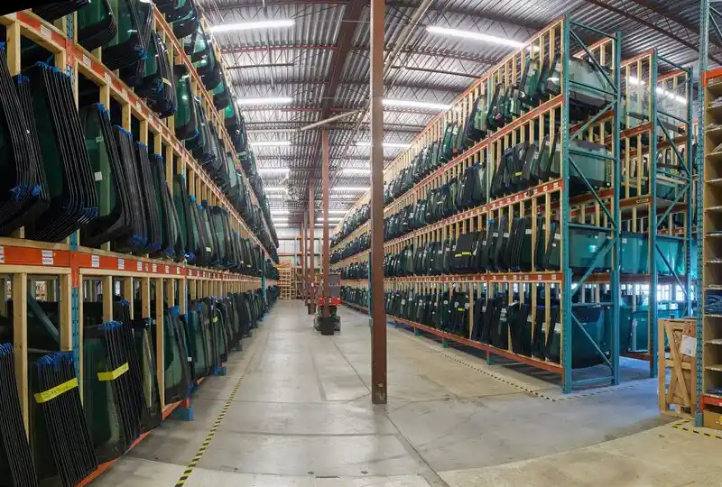 Automotive glass stored along a wide warehouse aisle